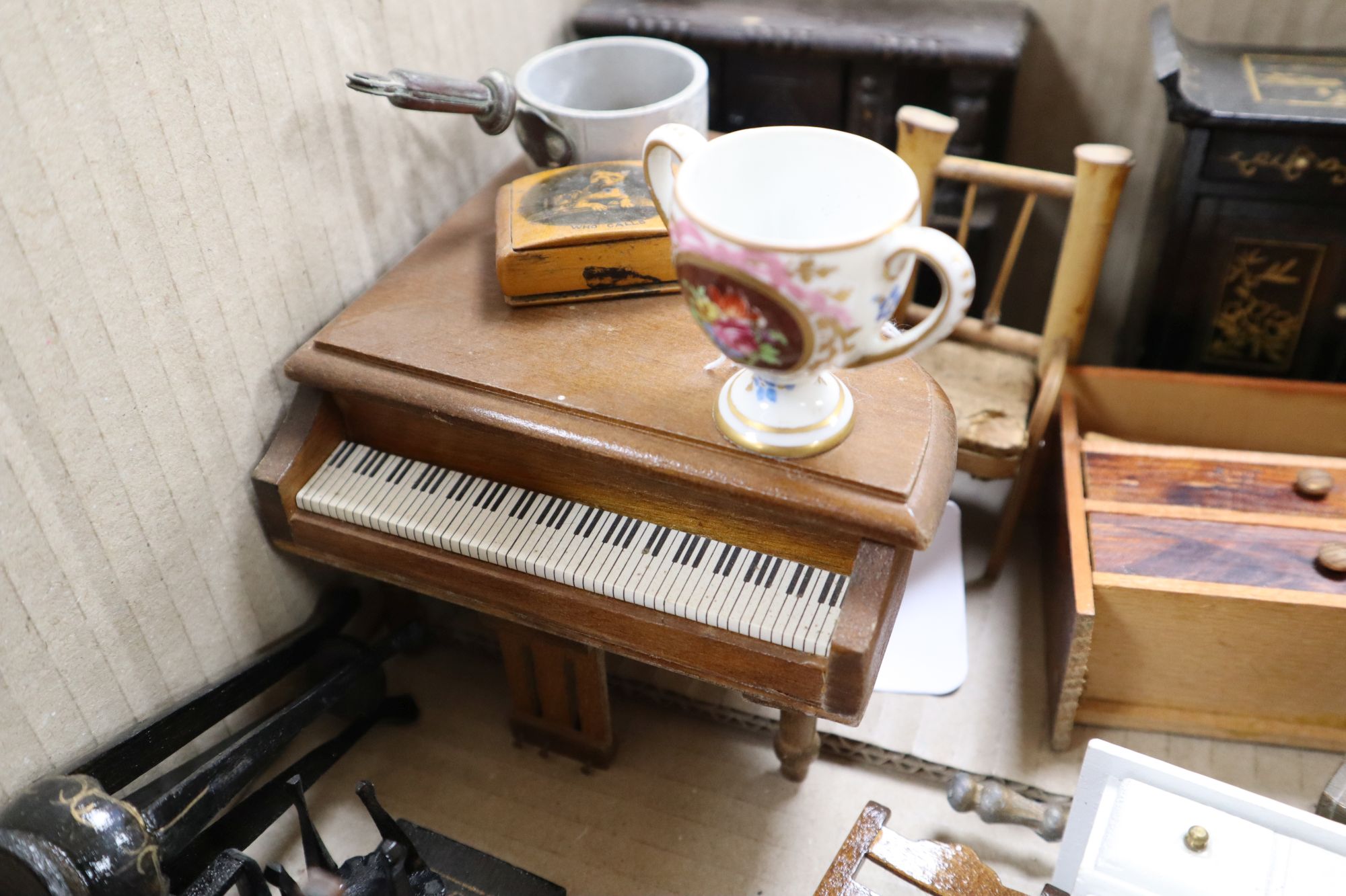 A collection of dolls and dolls house furniture displayed in room settings in a pine cupboard, width 84cm, depth 36cm, height 132cm